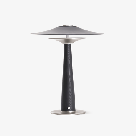 Bedroom table lamp with a wide disc on a black wood column, plain ground