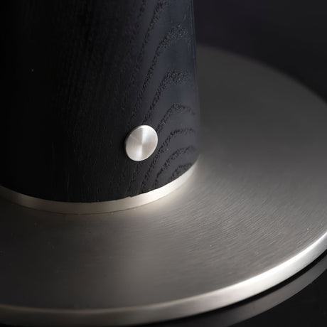 Close view of the brass touch button on the black wood column