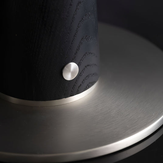 Close view of the brass touch button on the black wood column