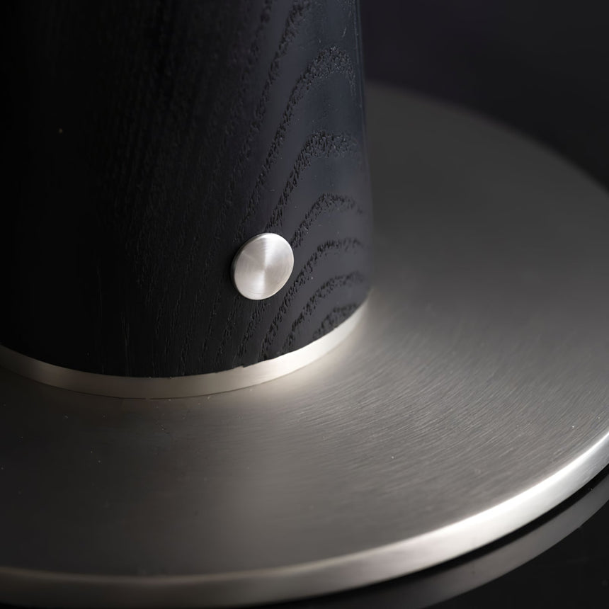 Close view of the brass touch button on the black wood column