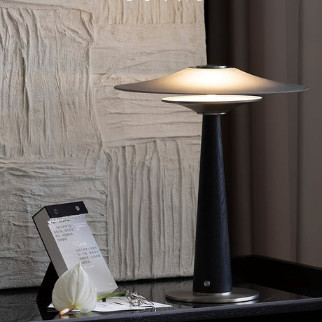 Bedroom table lamp lit beside a textured white plaster wall