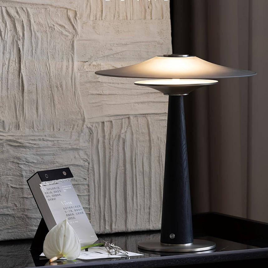 Bedroom table lamp lit beside a textured white plaster wall