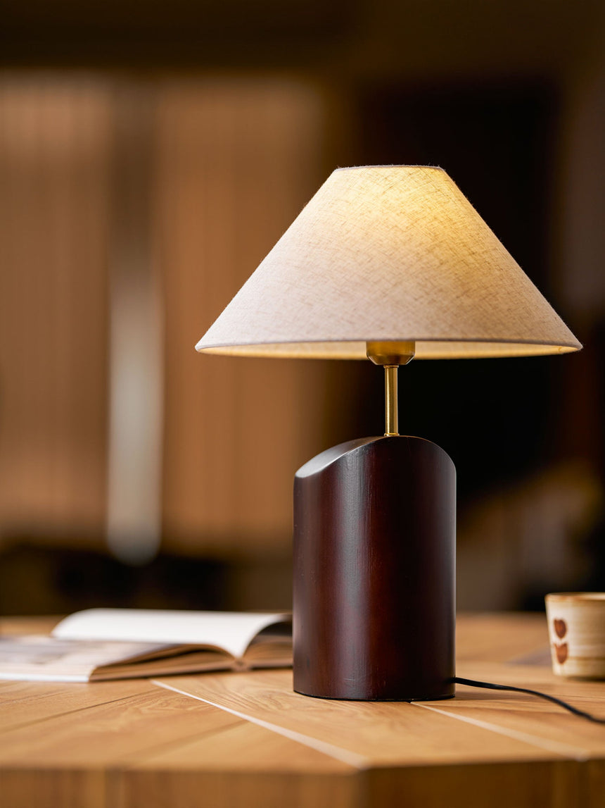 Bedroom table lamp lit on a desk in a dark room