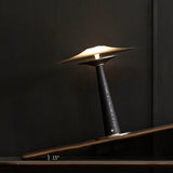 Bedroom table lamp lit and seen from a low angle on a dark surface