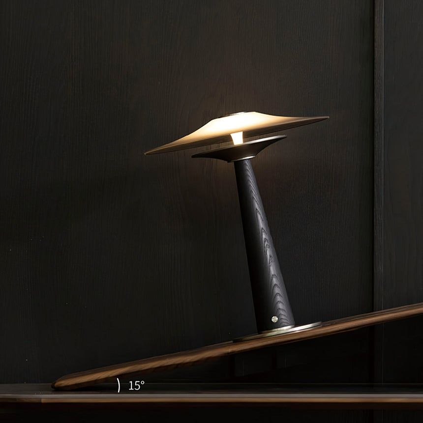 Bedroom table lamp lit and seen from a low angle on a dark surface