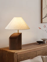 Bedroom table lamp on a wooden nightstand beside a small vase