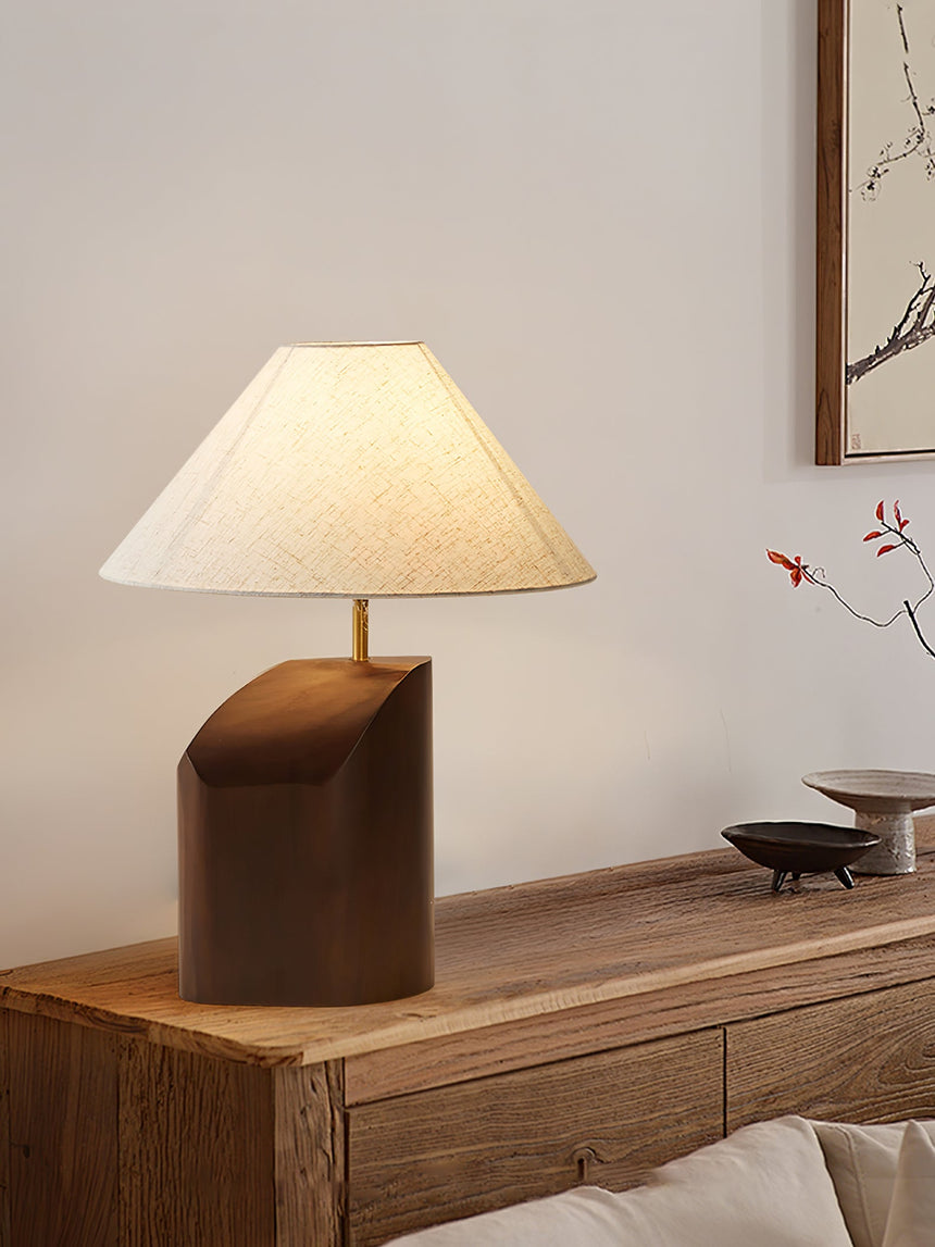 Bedroom table lamp on a wooden nightstand beside a small vase