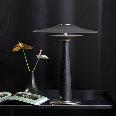 Bedroom table lamp on a dark tray beside an open magazine