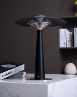 Bedroom table lamp on a marble plinth beside a book and a vase