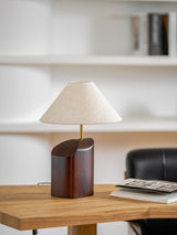 Bedroom table lamp on a desk against a wall of white shelves
