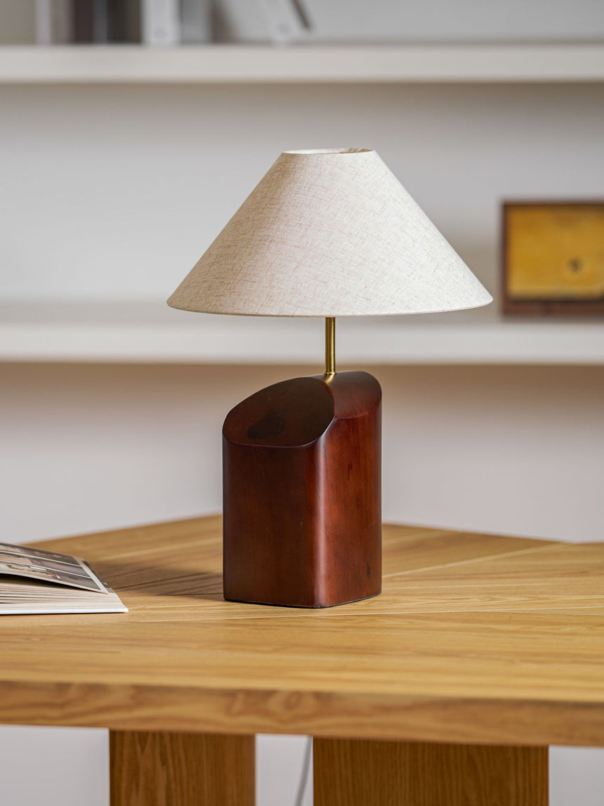 Bedroom table lamp on a wooden desk in front of white shelving
