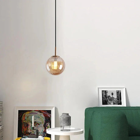 Amber sphere hanging in a bedroom beside a framed print and a green sofa