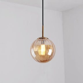 Amber glass sphere with a brass holder and a lit filament bulb inside