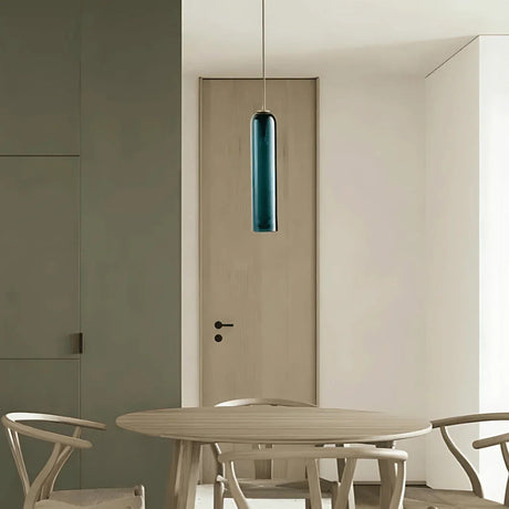 A green tube pendant lit beside a dining table and a doorway