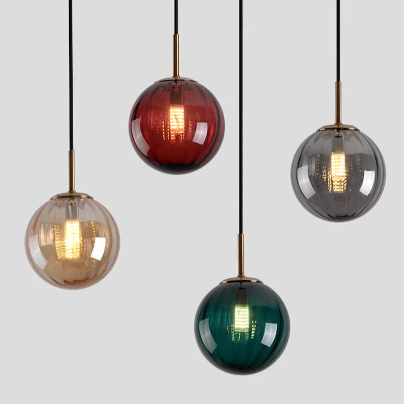 Four glass spheres in red, amber, smoke and green on a plain gray field
