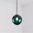Deep green glass sphere with a brass holder and a lit bulb inside