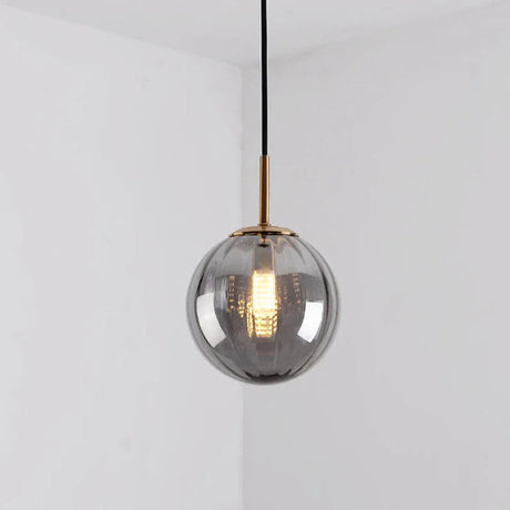Smoke gray glass sphere with a brass holder and a lit bulb inside