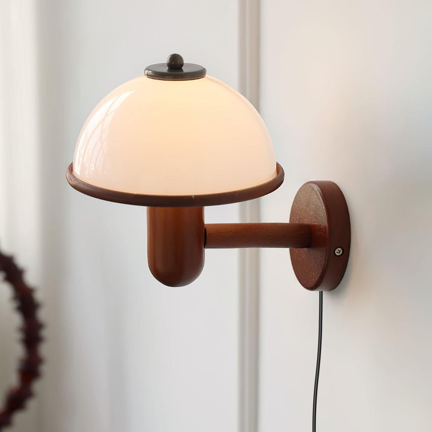 Close view of the white dome shade meeting the turned oak arm