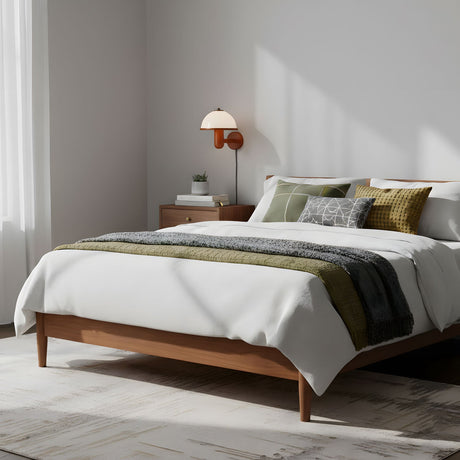 Oak wall lamp lit on a bedroom wall above a wood bed and green bedding