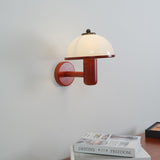 White dome shade and oak arm photographed small against a plain wall