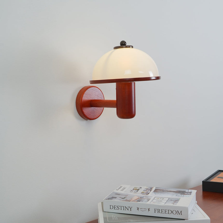 White dome shade and oak arm photographed small against a plain wall