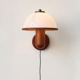 Oak wall lamp with a white dome shade and a cord running down the wall