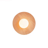 The smallest oak disc with the frosted globe lit warm at its center