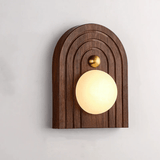 Close view of a white alabaster orb set into a grooved arched wood plate