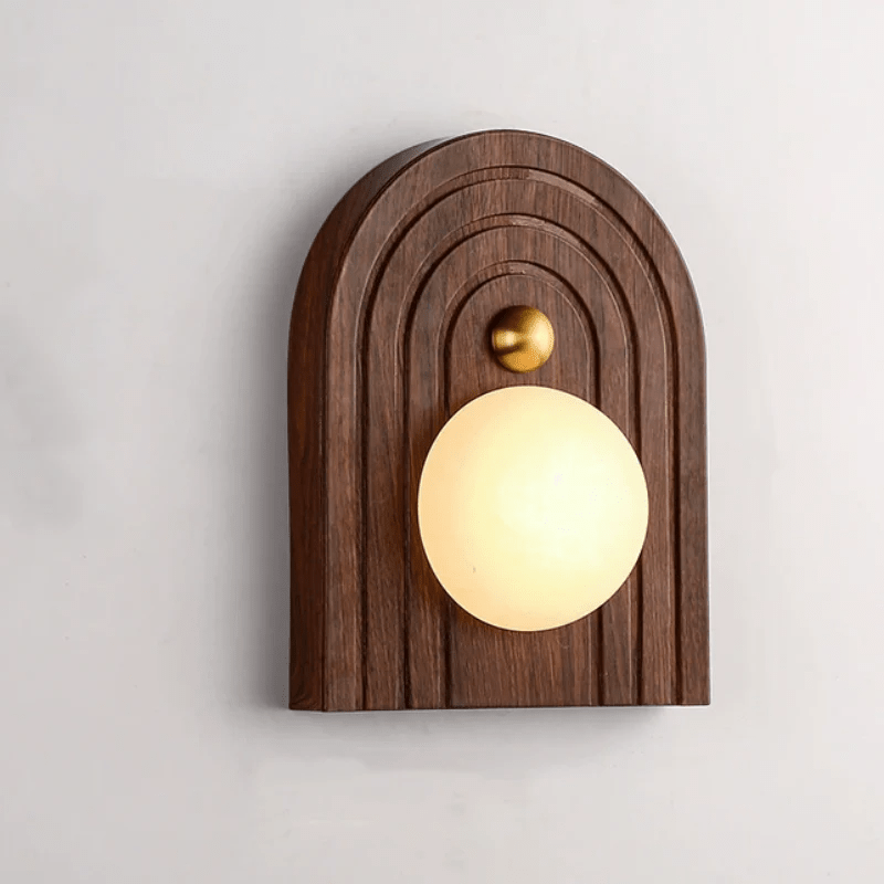 Close view of a white alabaster orb set into a grooved arched wood plate