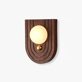 Bedside wall sconce with an alabaster orb on an arched walnut wall plate
