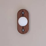 Alabaster orb lit cool white on an upright oval walnut plate