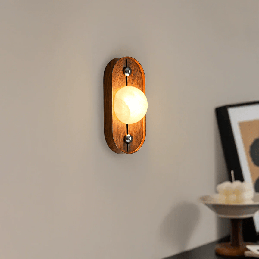Alabaster orb lit on an oval walnut plate above a small sideboard