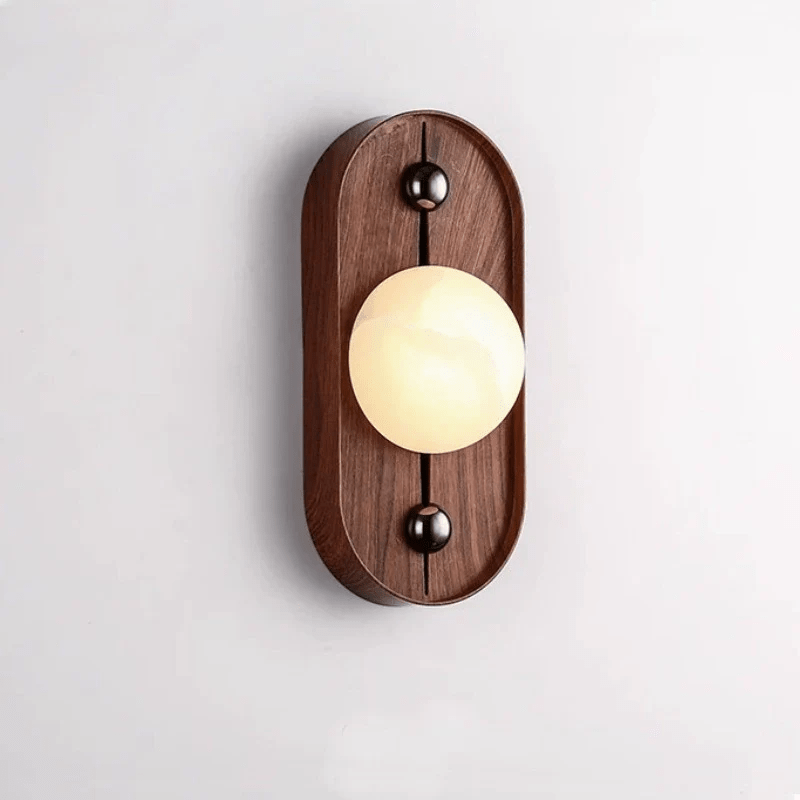 White alabaster orb on an oval walnut plate with two dark end fittings