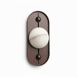 Alabaster orb showing its veining, set on a tall oval walnut plate