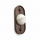 Alabaster orb on a tall narrow oval walnut plate, seen unlit