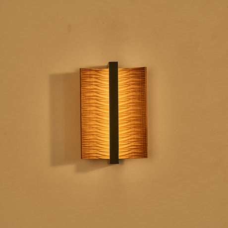 The fitting lit, warm light washing out from behind both curved wings