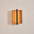 The pale wood version lit, the two wings curling forward off the wall
