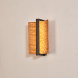 The fitting unlit, its own shadow falling across the wall behind it