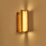 The fitting lit high on a wall, light thrown up and down the plaster