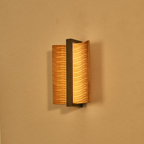 The pale wood version lit against a warm ochre wall, glowing at the slot