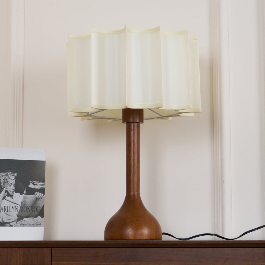 Close view of the lit scalloped shade and the turned oak stem