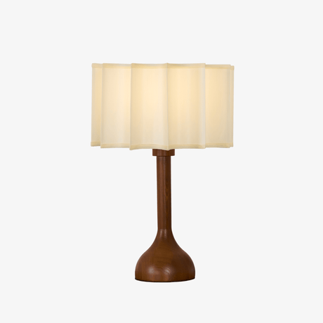 Beige table lamp with a scalloped shade on a turned oak stem
