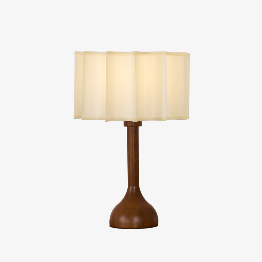 Beige table lamp with a scalloped shade on a turned oak stem