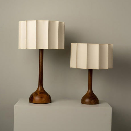 The small and large beige table lamps side by side on plinths