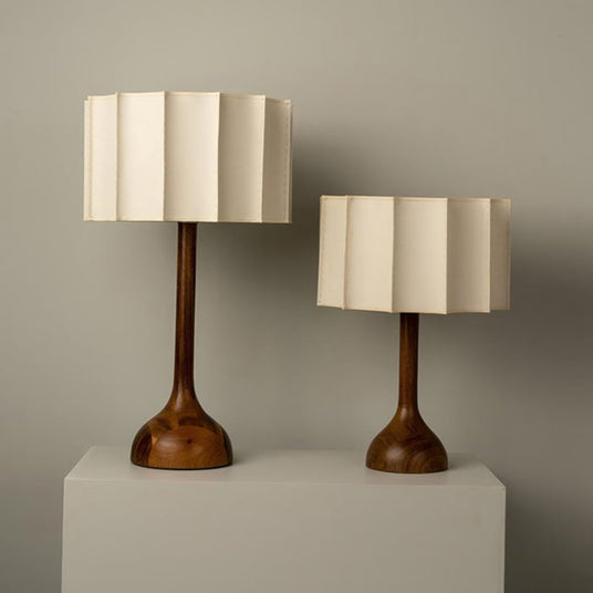 The small and large beige table lamps side by side on plinths