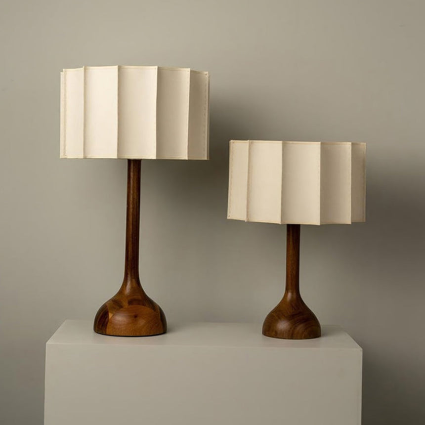 The small and large beige table lamps side by side on plinths