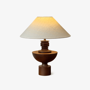 Beige table lamp with a wide shade on a turned wood vase base, plain background
