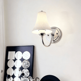 The sconce on a pale wall above a black and white print