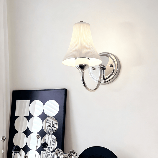 The sconce on a pale wall above a black and white print
