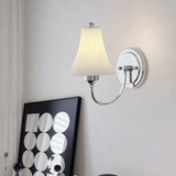 The sconce lit above a print with a pattern of white circles
